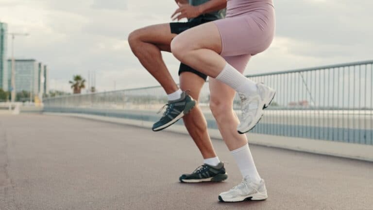 นักวิ่งกำลังวอร์มก่อนวิ่งด้วยท่าวิ่งยกเข่าสูง